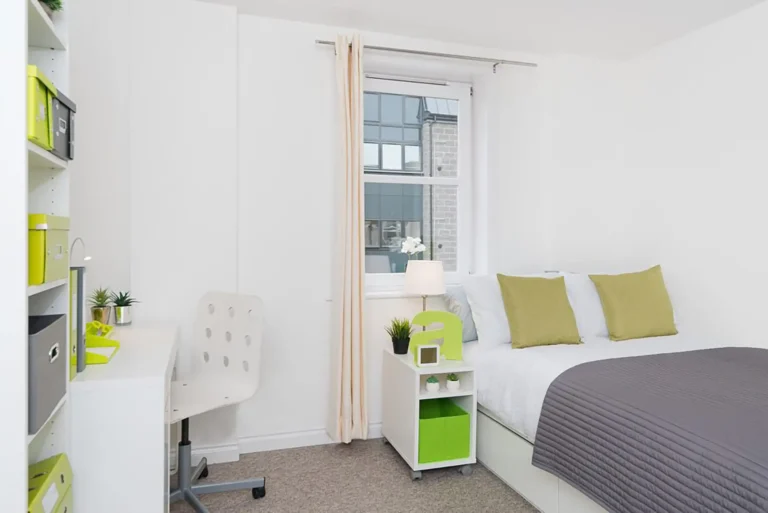 A bedroom at Froghall. There is a desk and shelving against the left wall, a good sized bed on the right. The room is spacious and light.