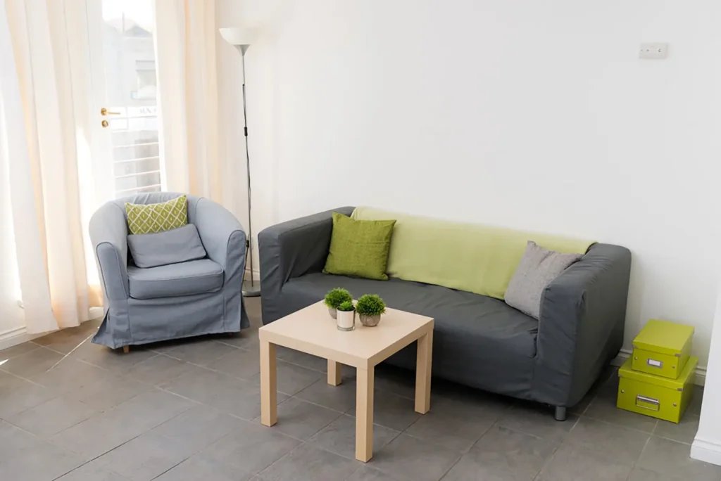 A living space at Linksfield. There is a comfortable single seat and a two person sofa in a light, spacious room